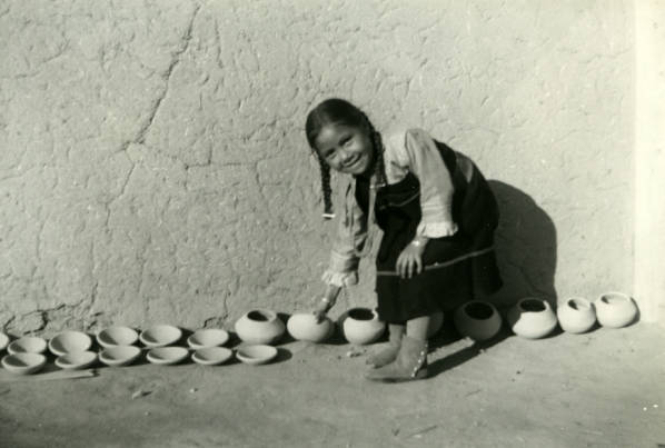 Young girl showing pottery she has made at San Ildefonso Pueblo, NM.
